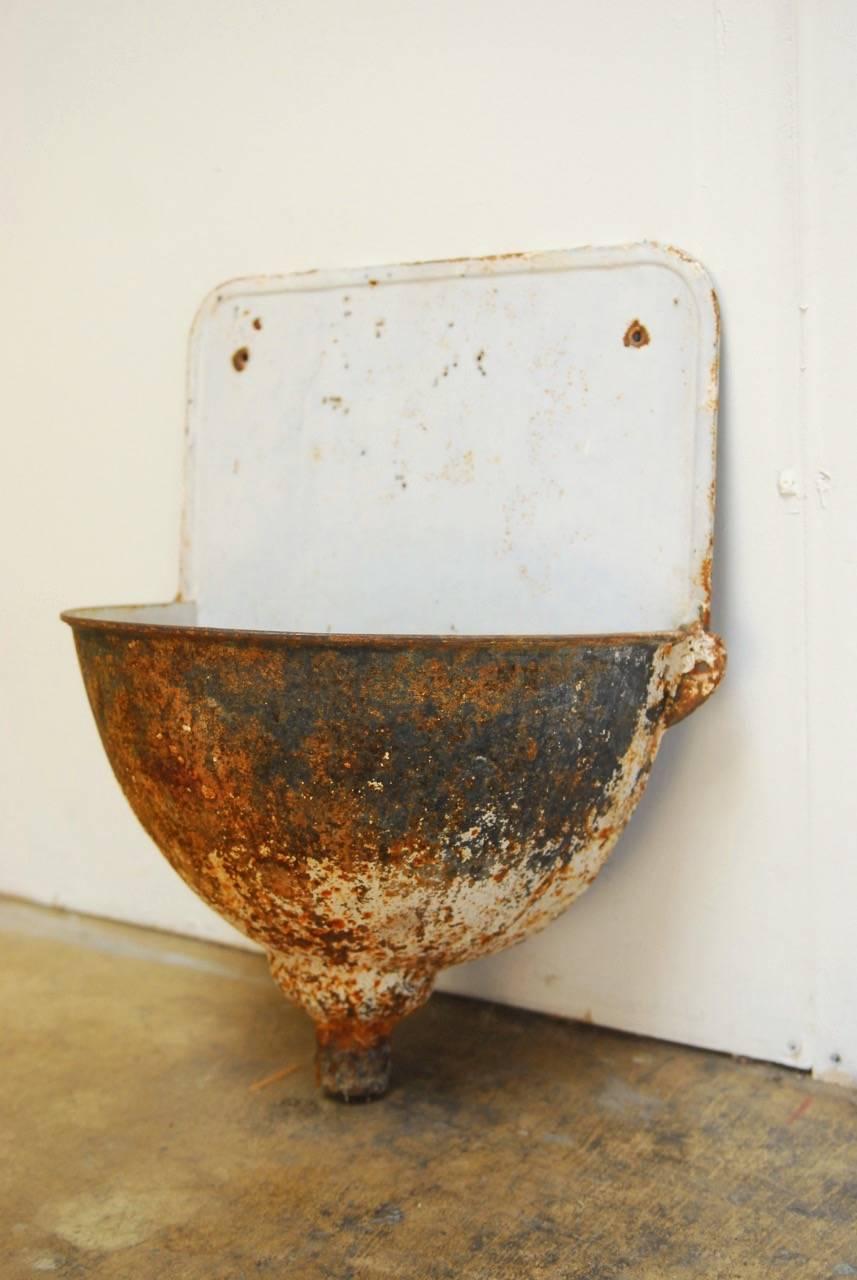 Rustic French farmhouse enameled iron garden sink planter or wall fountain. Known as Lavabo sinks in 19th Century Europe. These were hung on walls for washing. Beautifully distressed finish with exposed and patinated iron on the outside while still