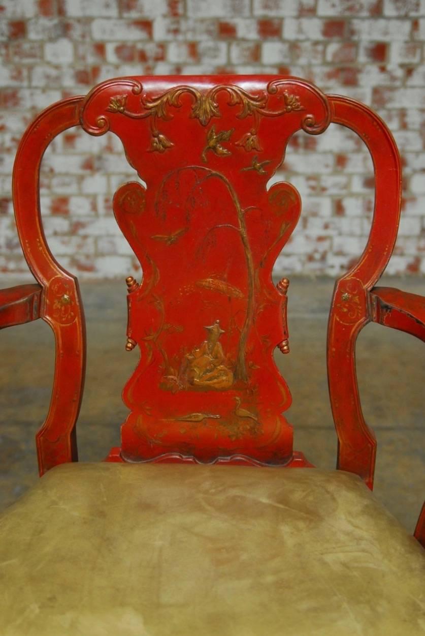 English Chinese Chippendale style red lacquer armchair decorated in the chinoiserie taste with gilt idyllic scenes on the back splat and trim. Generous round seat accented by vintage metallic leather upholstery and wide serpentine arms. Supported by