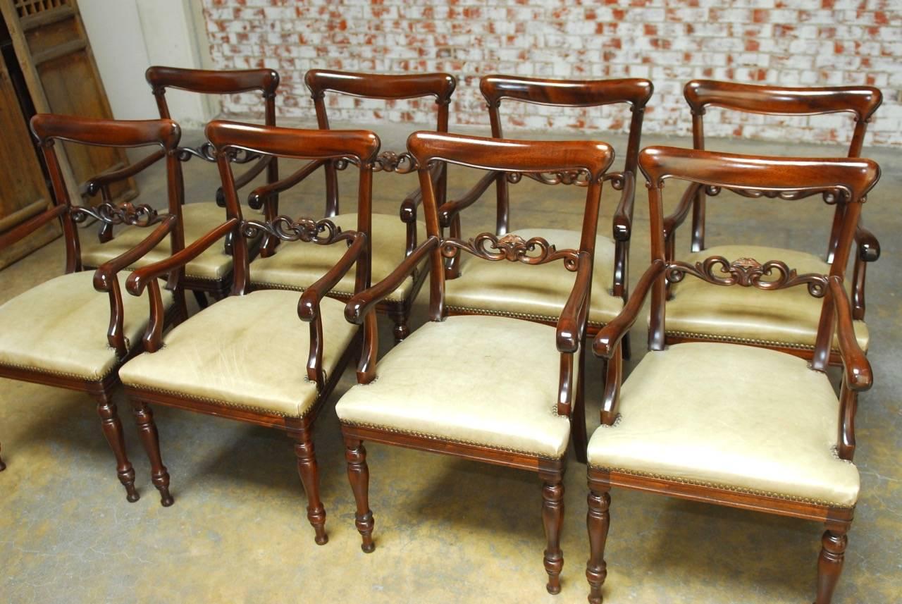 Extraordinary set of eight Regency style mahogany and leather dining armchairs. Each chair is constructed from radiant grain mahogany with a scrolled back splat and generous leather seat accented by brass nailhead trim. The frames have long,