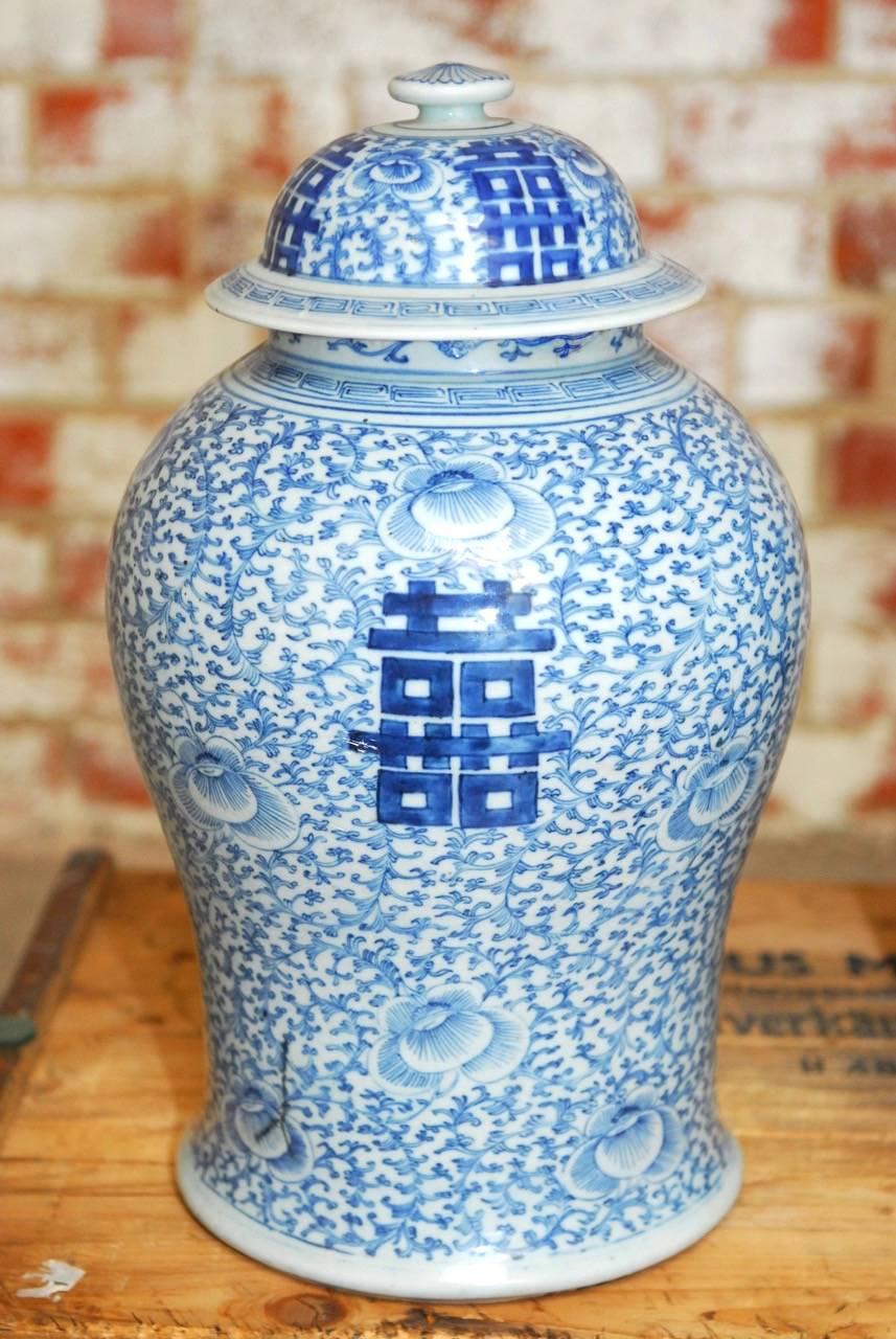 Impressive pair of Chinese blue and white porcelain ginger jar vases. Featuring a scrolling vine pattern background and a double happiness design on each. Very slight variations in forms and height with a pleasing faded finish. Chenghua Ming period