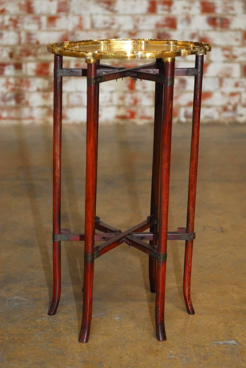 Attractive six-leg folding brass tray table or drinks table with a matching serving tray. Features an elegant six-leg folding wooden base supporting a round incised brass tray with a conforming smaller tray inside. Each tray has a decorative