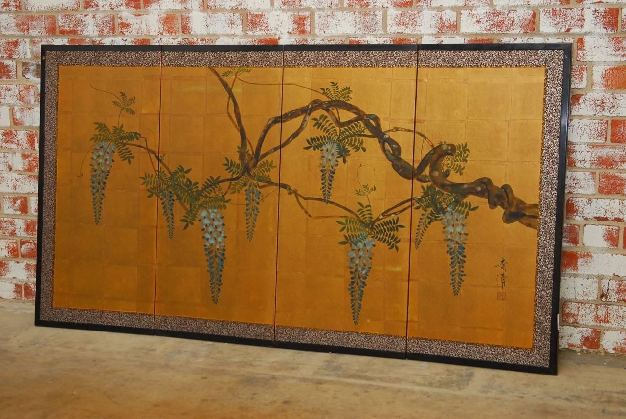 Japanese four panel Byobu screen of a flowering wisteria vine on gold leaf. Twisted vines with colorful blue flowers and green foliate contrasted by a gilt background. Set with a brocade silk border in an ebonized wooden frame. Signed and sealed on