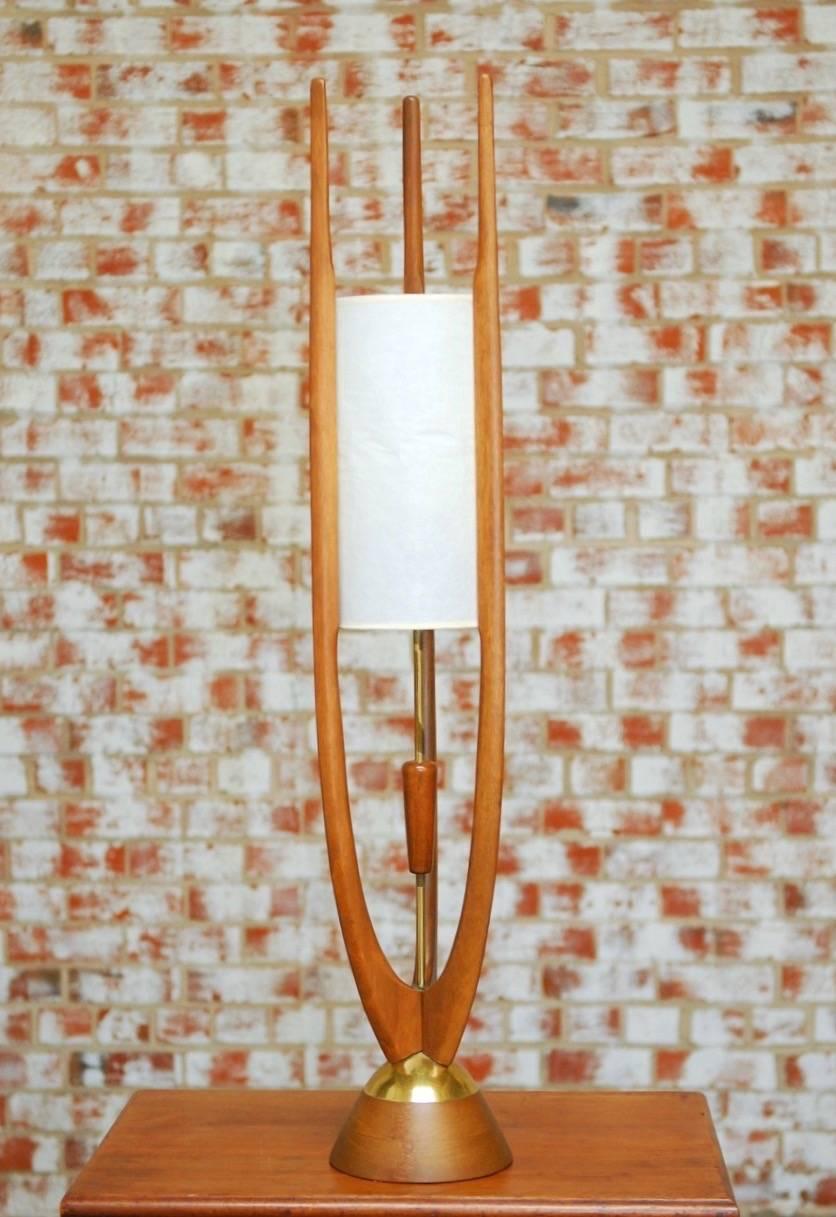 Magnificent midcentury Danish modern style rocket lamp by Modeline of California. Constructed from teak featuring three sculptural sabre arms with a brass center column that controls a pull chain. One inner shade made of organic paper fiber and a