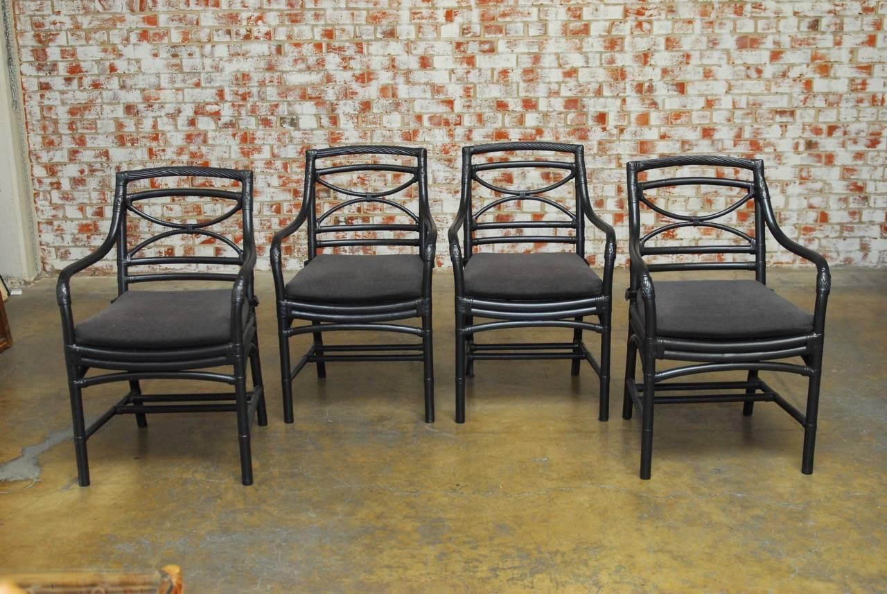 Stylish set of four McGuire style bamboo and rattan armchairs featuring a fresh black lacquer redux. Beautifully constructed in the McGuire style with bamboo and leather rawhide strapping. Each chair has a decorative demilune motif back and a