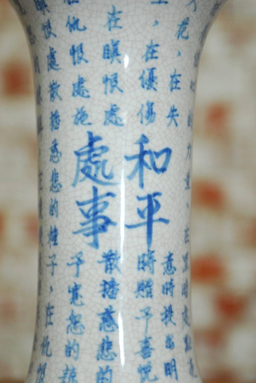 Vintage Chinese blue and white porcelain trumpet vase featuring Chinese script and a beautiful craquelure finish glaze. 20th century Chinese export piece with illegible stamp on bottom.