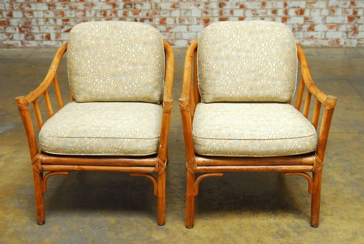 Classic pair of organic modern bamboo lounge chairs by McGuire. Featuring graceful bent bamboo arms with column supports and thick cushions. The frame is reinforced with leather rawhide strapping. Richly decorated modern McGuire fabric with a floral