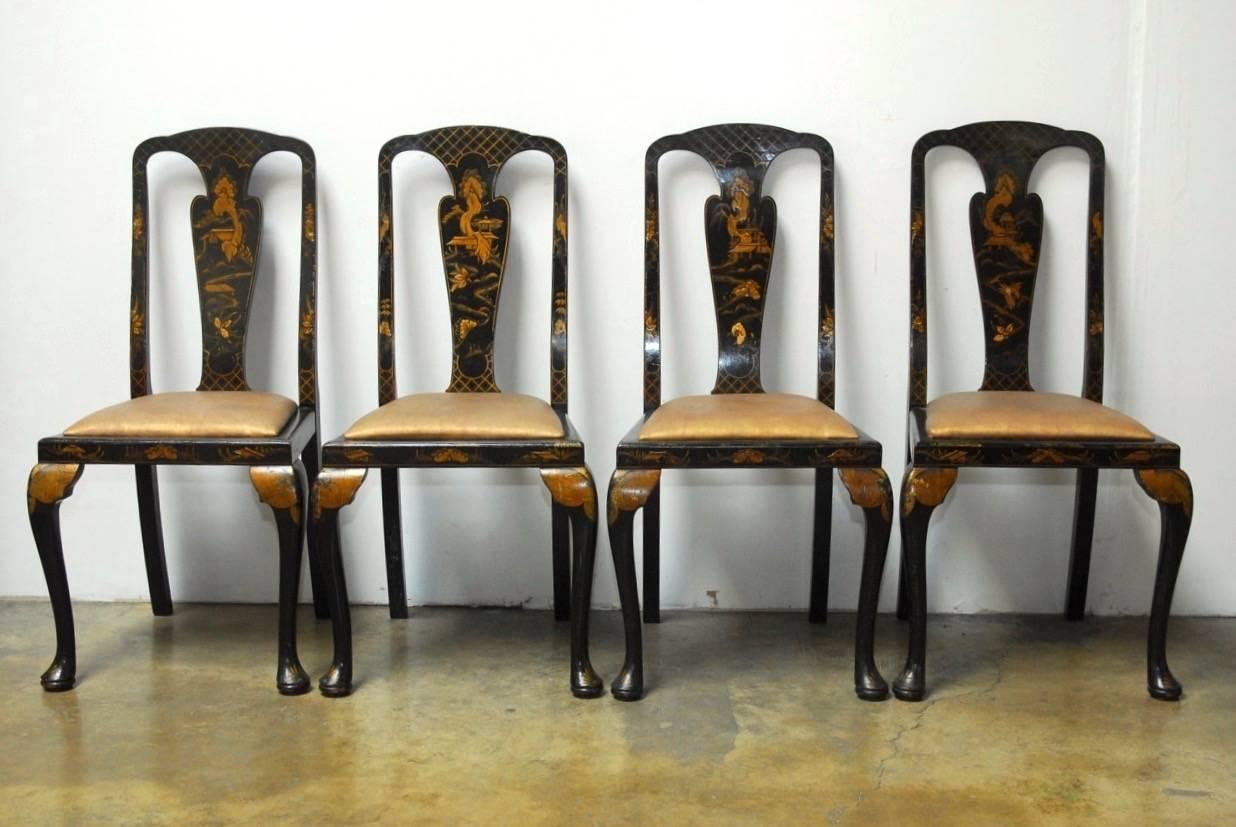 Exceptional set of six English Queen Anne style chinoiserie black lacquer dining chairs. Featuring a lacquer and parcel-gilt finish with Japanned scenic reserves on the black splats, and frames. Set consists of two armchairs and four side chairs all