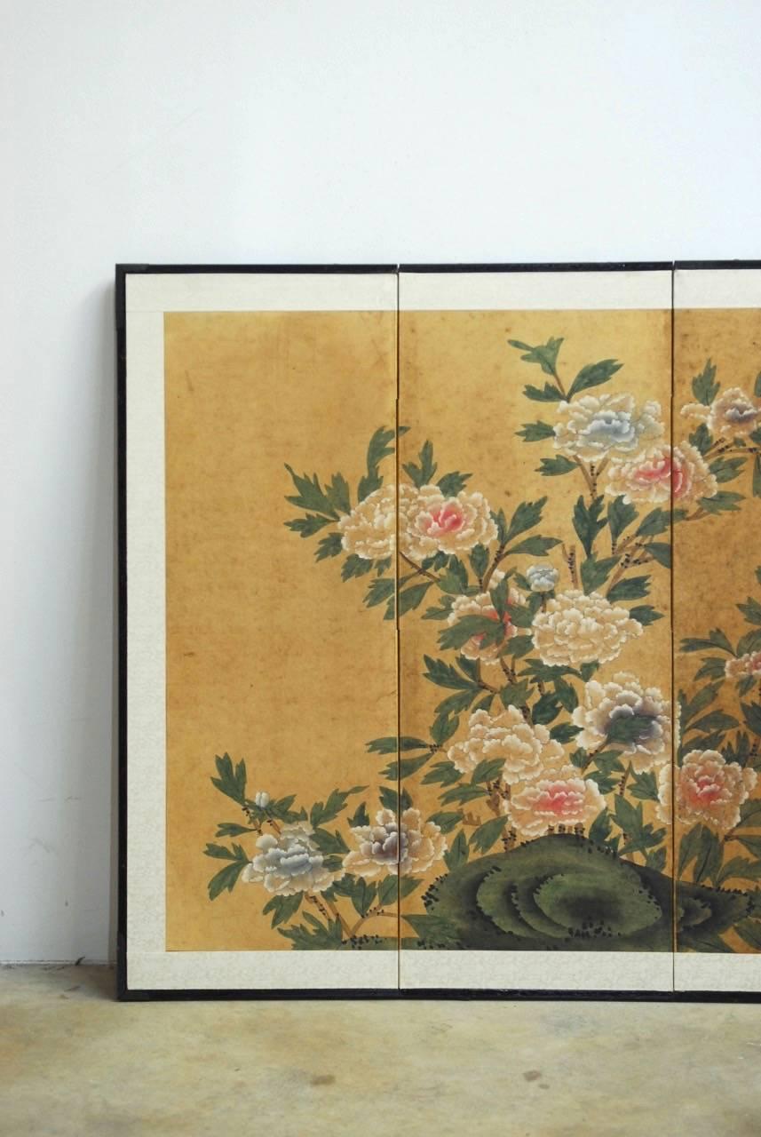 Colorful Japanese four panel byobu screen featuring a large floral and foliate bloom drawn on paper. Beautifully decorated with intricate details on an organic textured paper and bordered by a light, silk brocade. Set in ebonized frame with brass