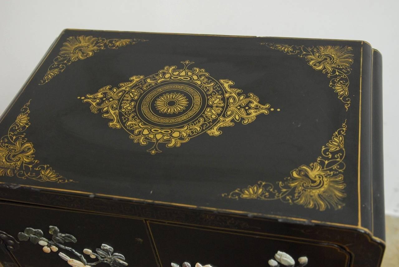 Stunning Chinese black lacquer soapstone and hardstone scholar's cabinet. Fronted by two large doors above two smaller drawers supported by a shaped apron base. Beautifully decorated with hand-carved soapstone and hard stone embellishments with a