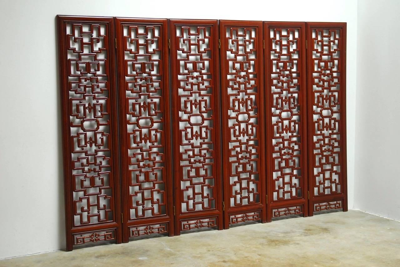 Fantastic Chinese six-panel Rosewood carved lattice folding screen. Features intricate geometric patterns with Greek key motif. Each panel is 17.5 inches wide and has a contrasting oval carved shape in the center and prosperity emblem carved between