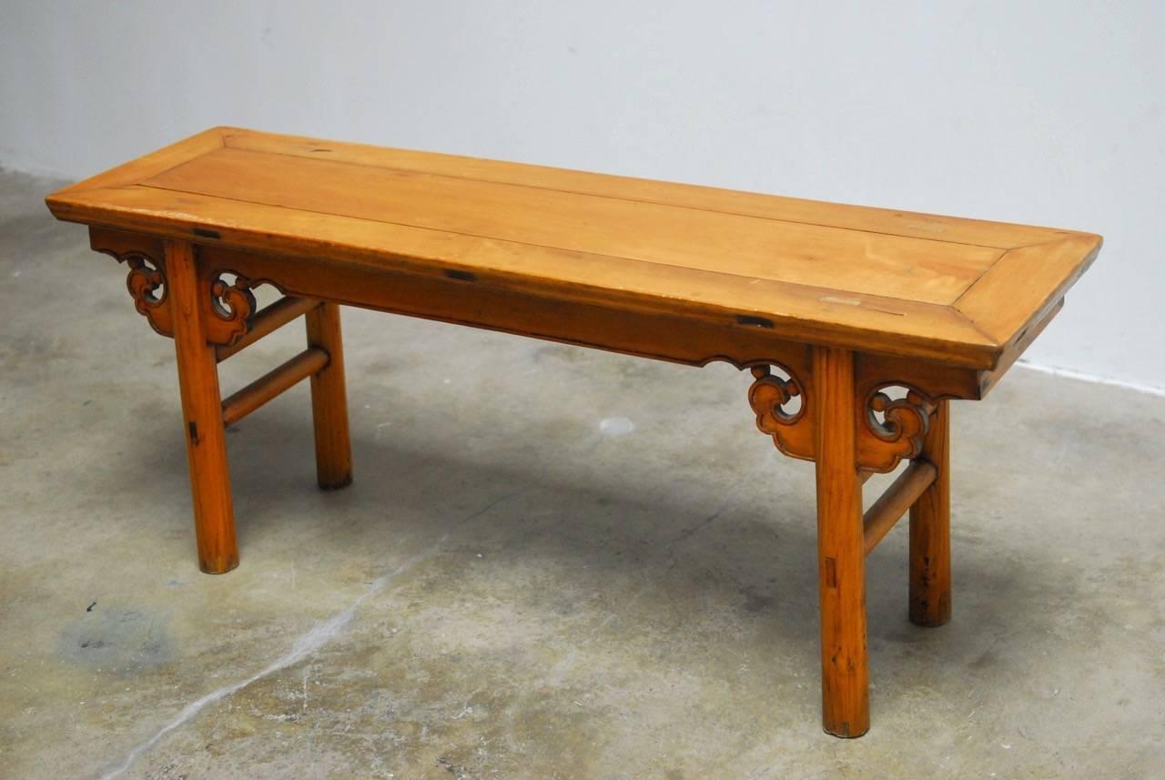Rustic 19th century hand-carved wooden bench or altar table. Made with mortise and tenon construction and featuring a decorative Ruyi cloud shaped apron. The table is supported by thick round legs with double stretchers. Originally finished in dark