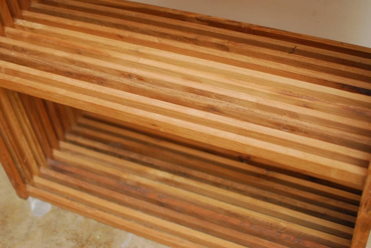 Stylish mid-century modern teak display shelves or bookcase with five shelves. Constructed from teak slats with wood peg joinery. Open shelving with a geometric style that could be used indoors or outdoors. 