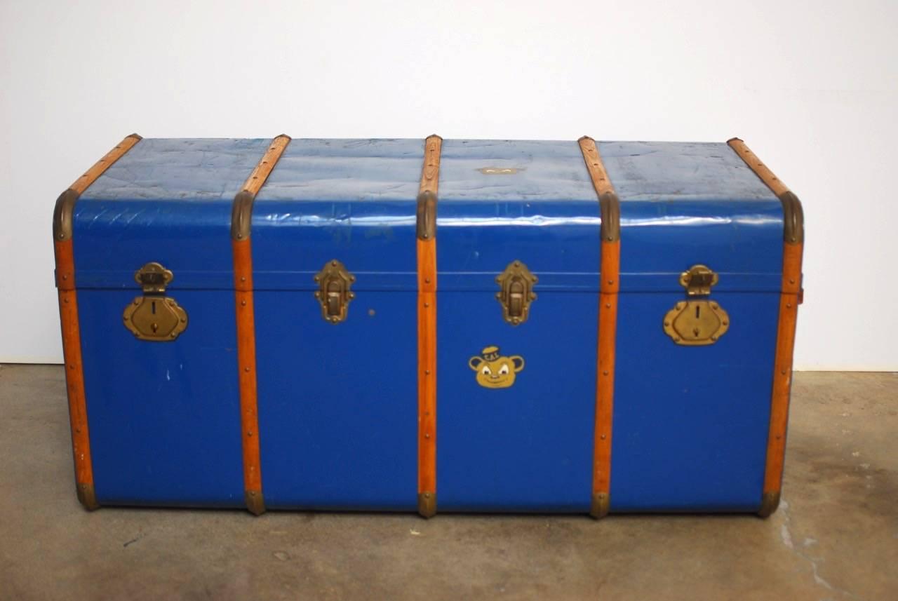 Stunning French blue traveling steamer trunk constructed from a wooden frame with metal cladding. Features 5 wooden straps protecting the outside with brass mounted corners. The front has four latches, two locking and two non locking. Finished in a