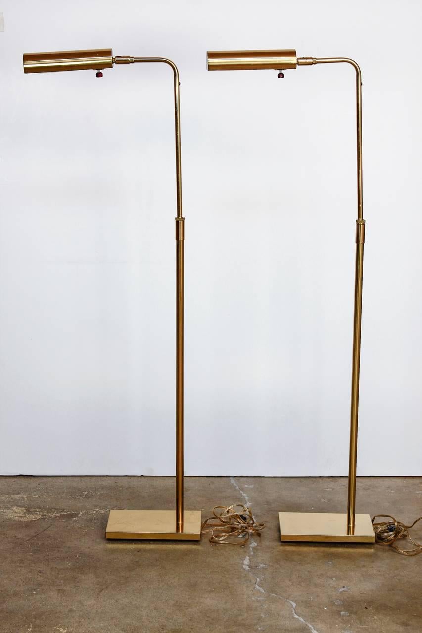 Elegant pair of Koch and Lowy adjustable brass reading floor lamps or pharmacy floor lamps. Featuring an adjustable or articulated arm that raises from 36