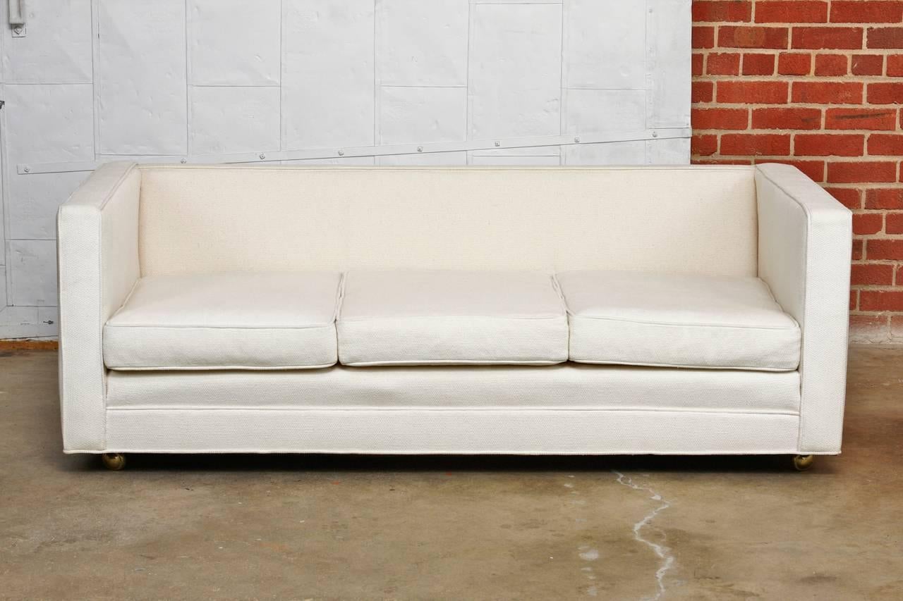 Milo Baughman style custom-made Mid Century Modern upholstered case sofa. Featuring a thick woven organic style cream upholstery made in San Francisco, CA. Supported by casters each with three thick cushions and a deep seat. Upholstery is in good