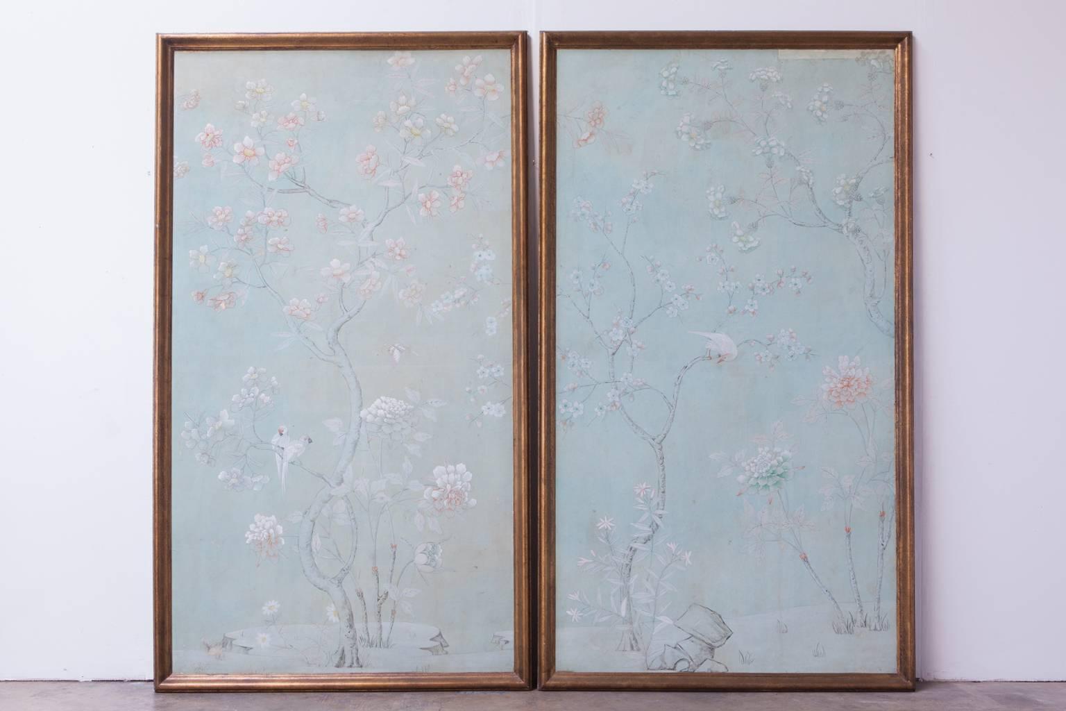 A dramatic 1950s pair of vintage, hand-painted, chinoiserie wallpaper panels mounted on board and showcased in a giltwood frames. They feature beautiful, hand-painted details of trees, birds and foliate. Frames are hand finished. Rare, robin's egg