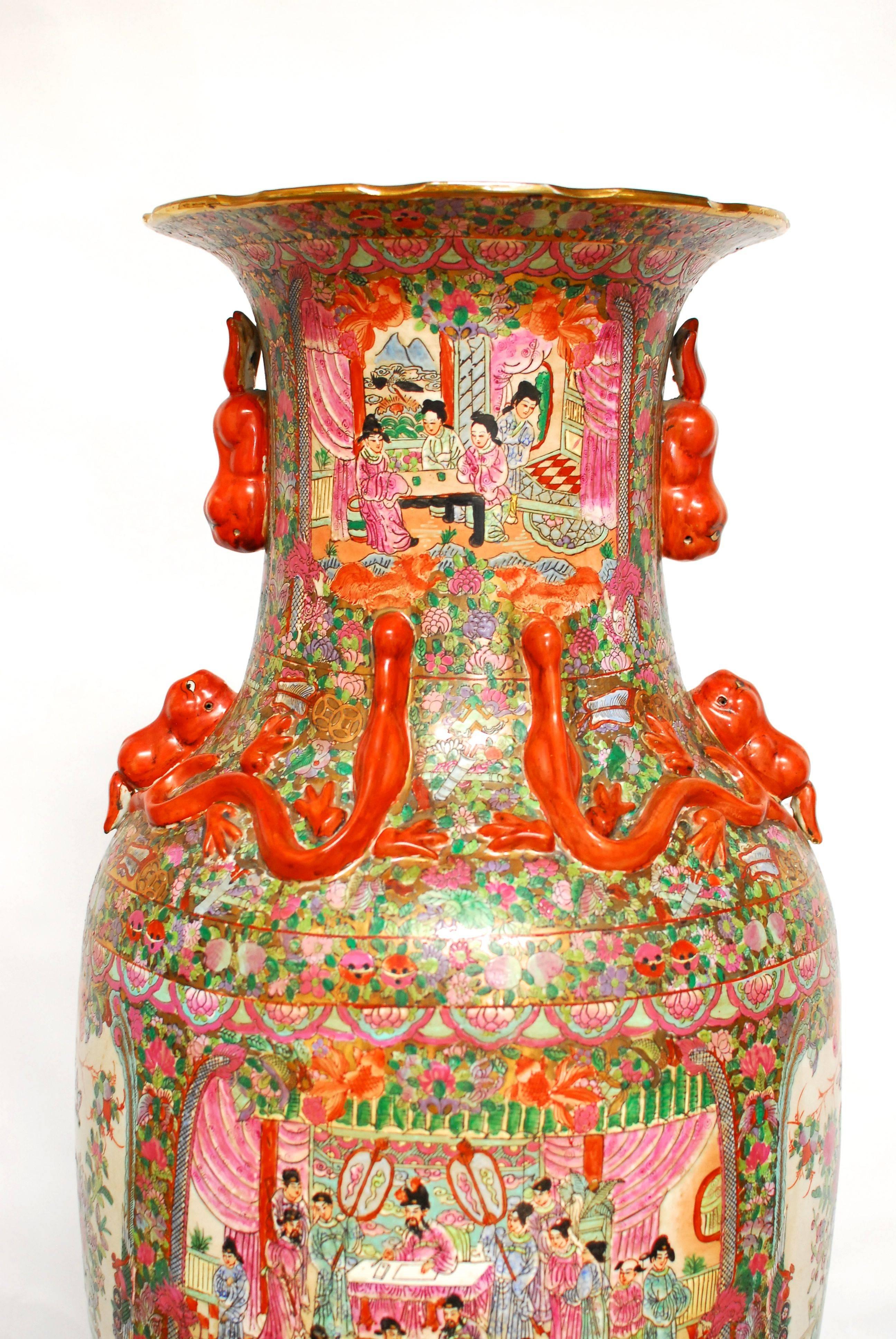 A monumental 19th century Chinese canton famille rose porcelain vase in a baluster shape with applied handles in the form of young temple foo dogs and lizards on the waisted neck. Numerous royal figures and court scenes on a highly decorated gilt