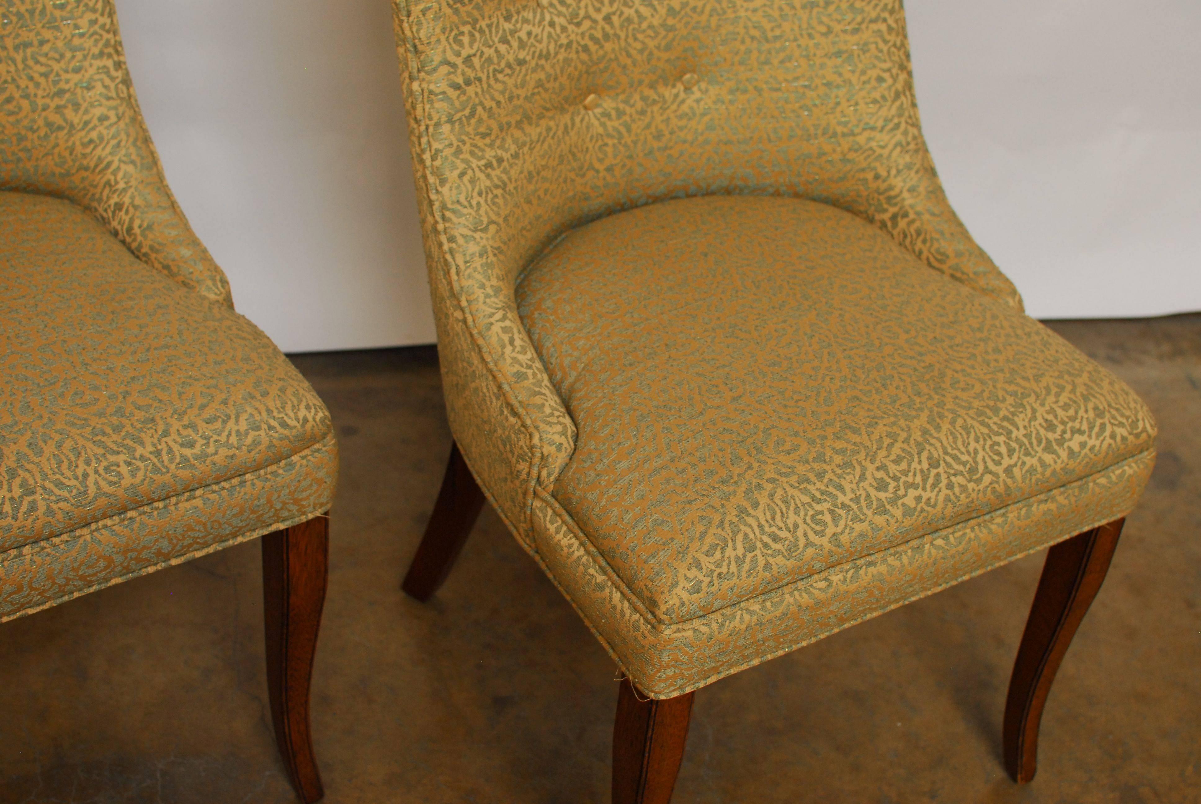 Chic pair of W.J. Sloane Mid-Century scoop back chairs featuring an animal print style pattern in a turquoise metallic and gold fabric. These chairs were made in 1956 with mahogany legs and tufted scoop back.
