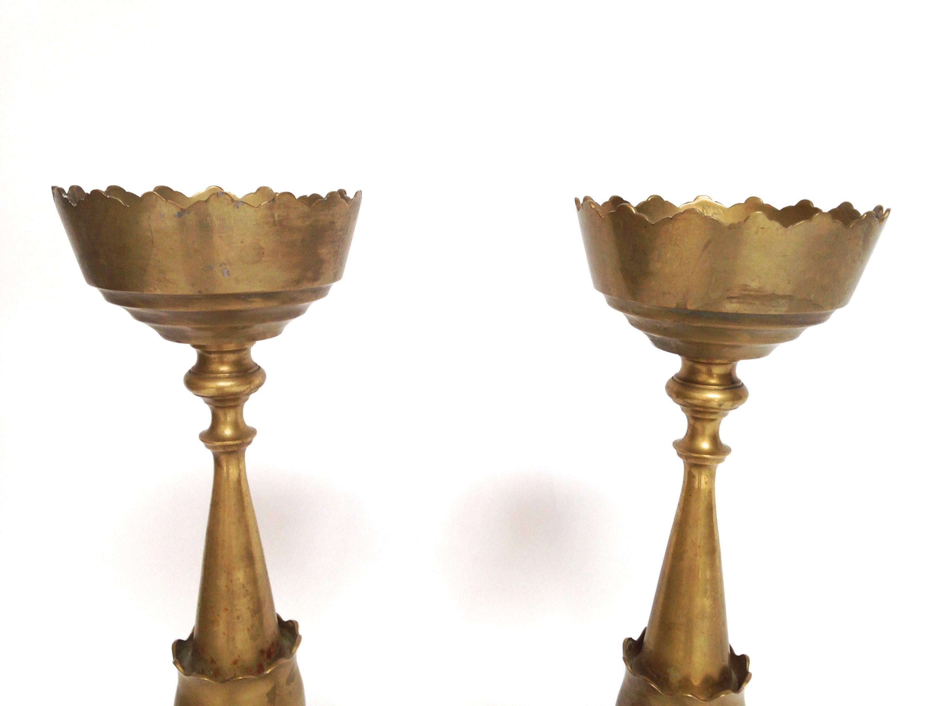 Pair of large antique brass Ottoman style candlesticks with tulip form Bobeche and long turned shaft, resting on a circular base. Very heavy and solid candle holders in excellent condition and beautiful vintage patina. Very unique. From a local San