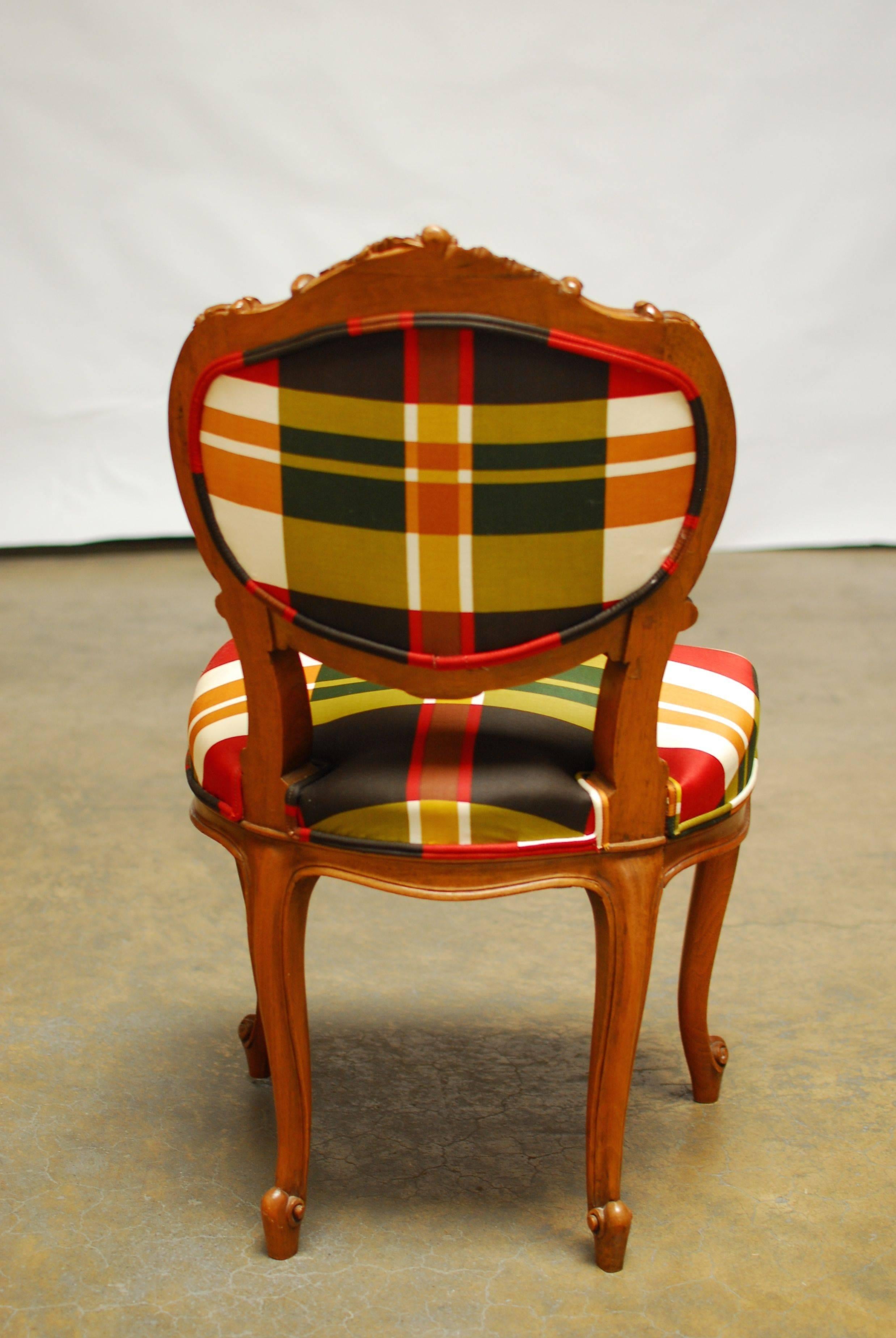 Pair of chic 19th century French Louis XV style chairs with a hand-carved walnut frame and cabriole legs. Featuring a Burberry style silk plaid upholstery with a double welt on the seat and back. Classic floral and foliate carved details on the
