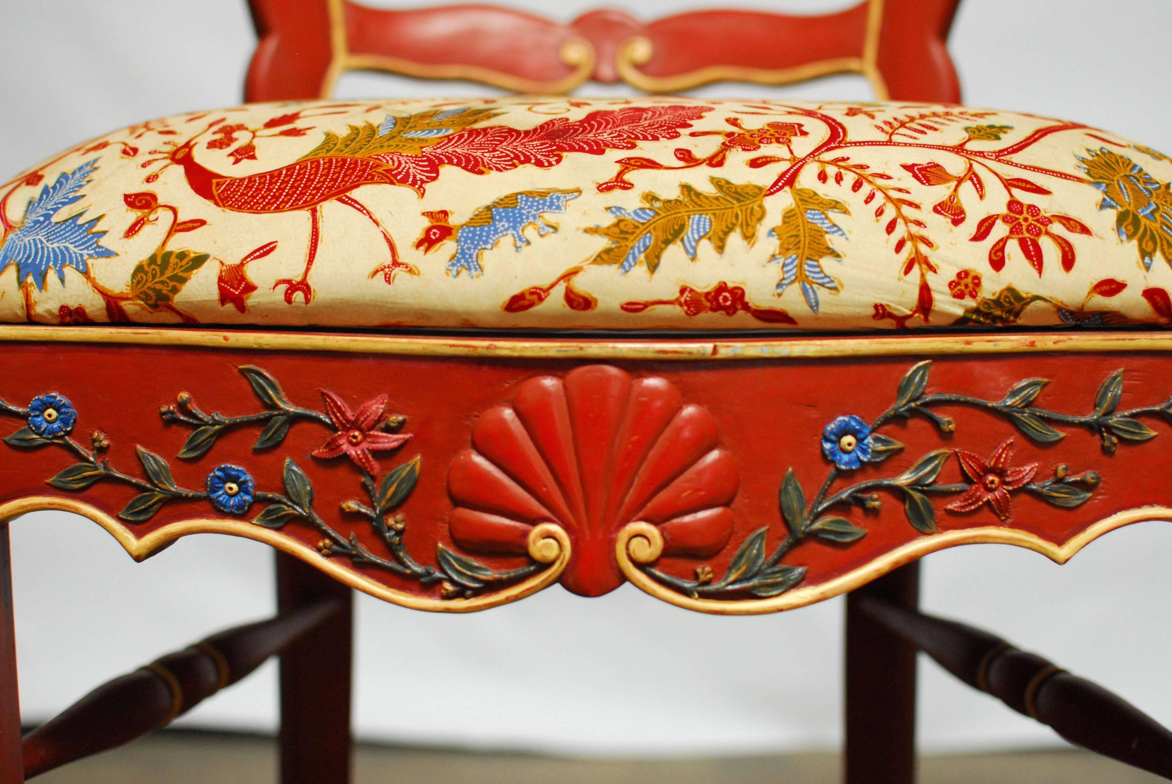 Rare set of four French country relief carved bar stools made in a Provincial style with a wide seat and back. Whimsical hand-carved cabriole legs and scroll arms with a frame decorated with foliate detail and a shell crest and apron. Bright red