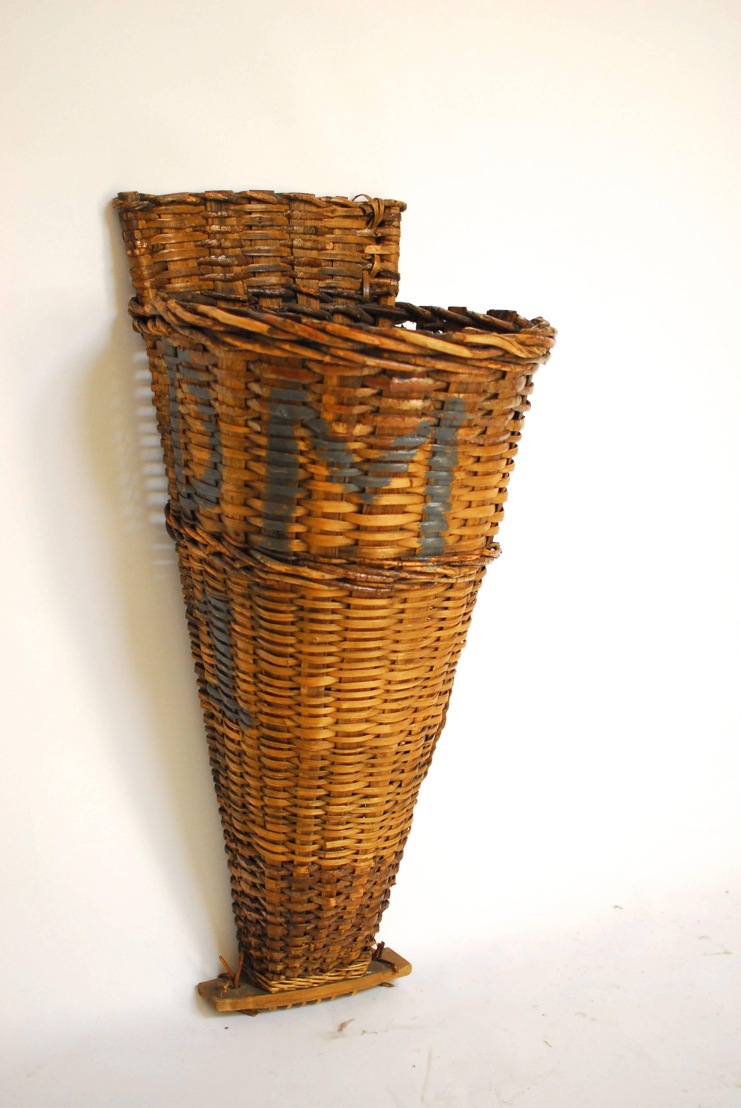 A tall, French harvest basket hotte made of woven willow and oak from the Champagne region of Burgundy, France. Beautifully woven with painted winery initials. The finish is warm and rich. Sits on a wooden base.
   