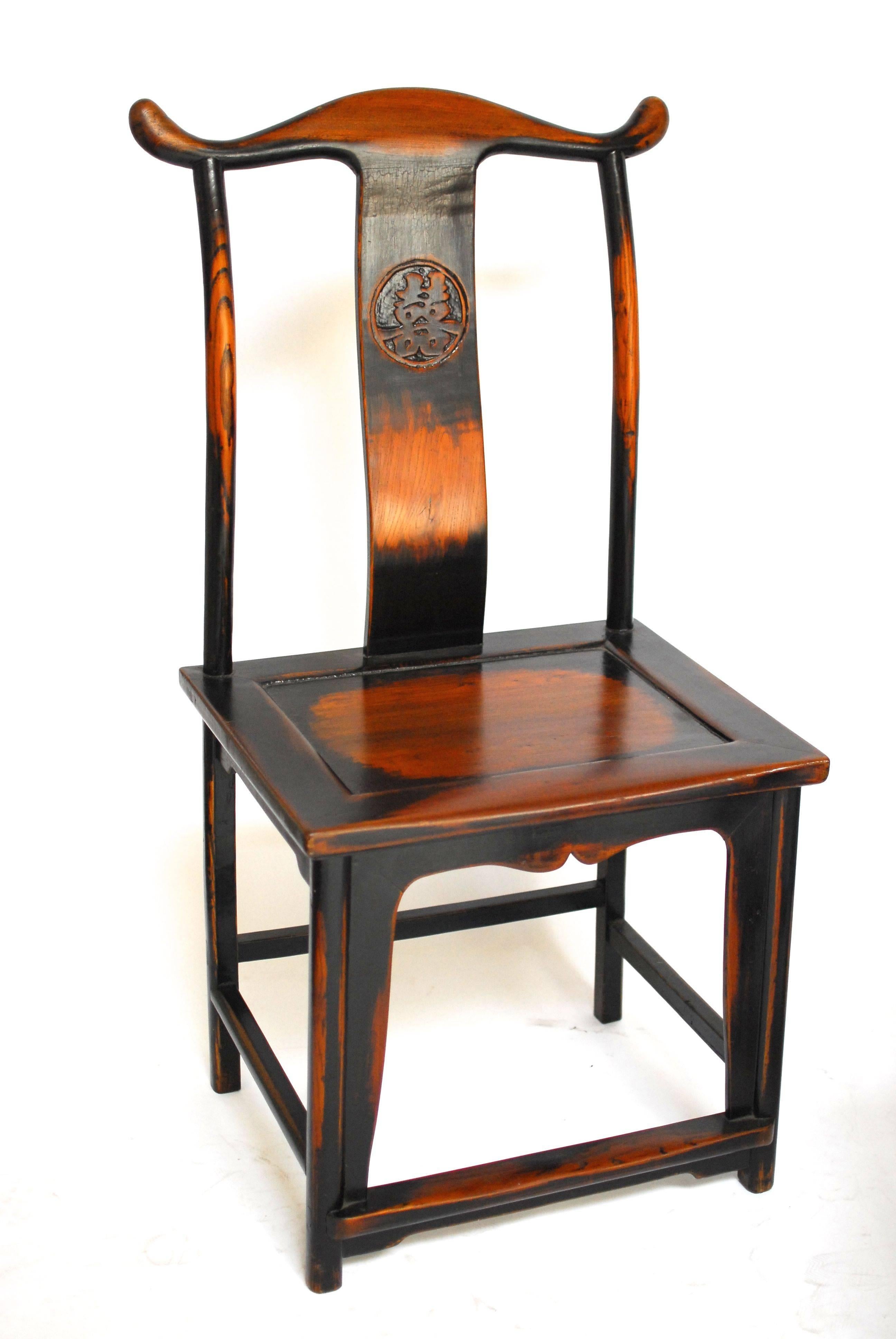 A set of five Chinese carved yoke back official's hat chairs finished in a rich dark lacquer. Distressed to look like they are hundreds of years old with vintage wear spots handcrafted by a local artisan. Two have been carved with a gui-dragon back