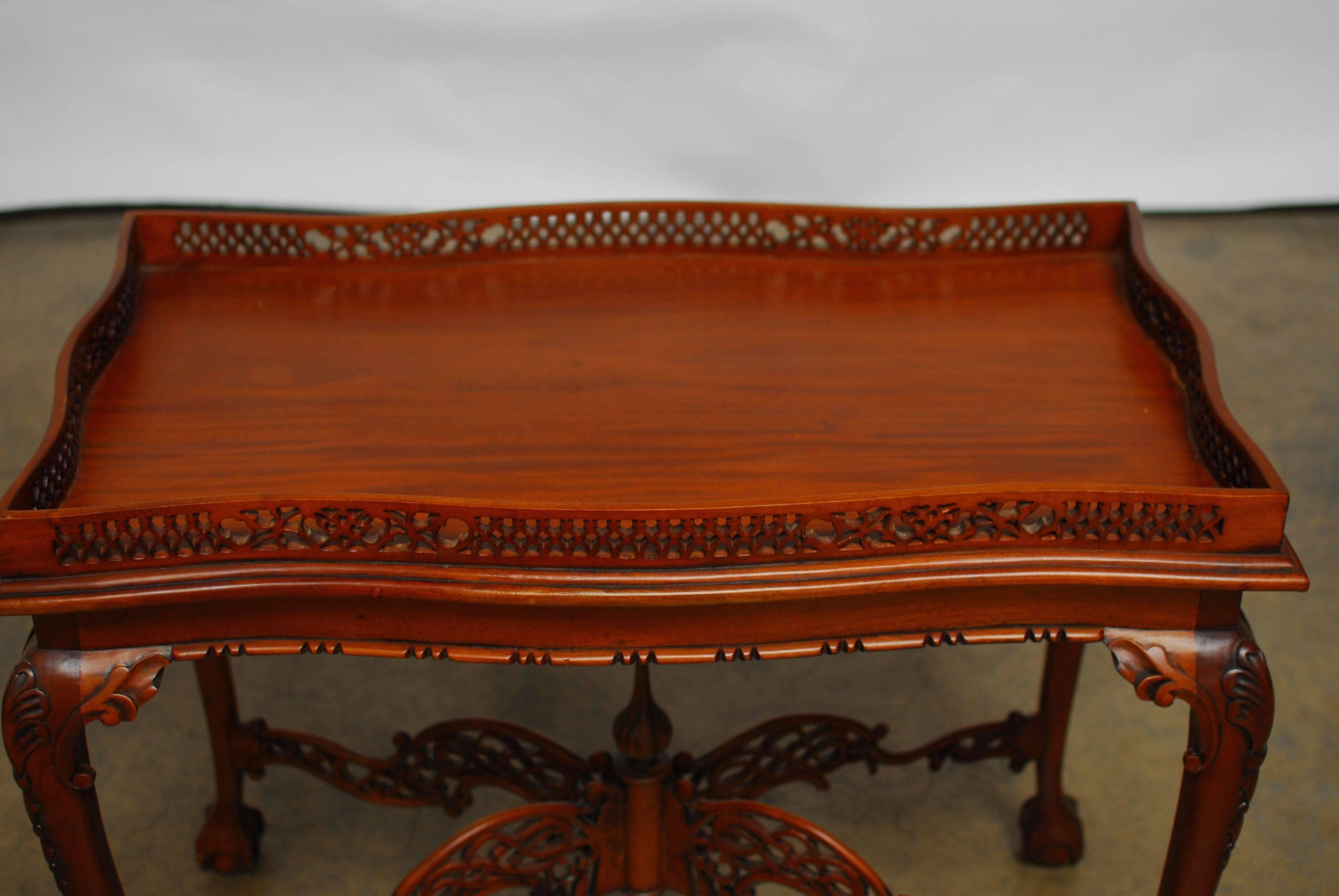 Rare, George III carved mahogany silver table in the Chinese Chippendale taste. Rectangular top with a pierced fretwork gallery. Table is supported by tapering cabriole legs with ball and claw feet. The legs are joined by an arched X-shaped