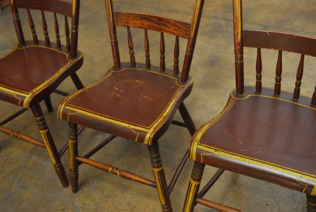 Rare set of six colorful Pennsylvania painted Hitchcock style chairs from the mid-19th century made in the manner of Lambert Hitchcock. Shaped crest rails with fruit painting over half-rails with turned spindle backs. Plank country seat and finished
