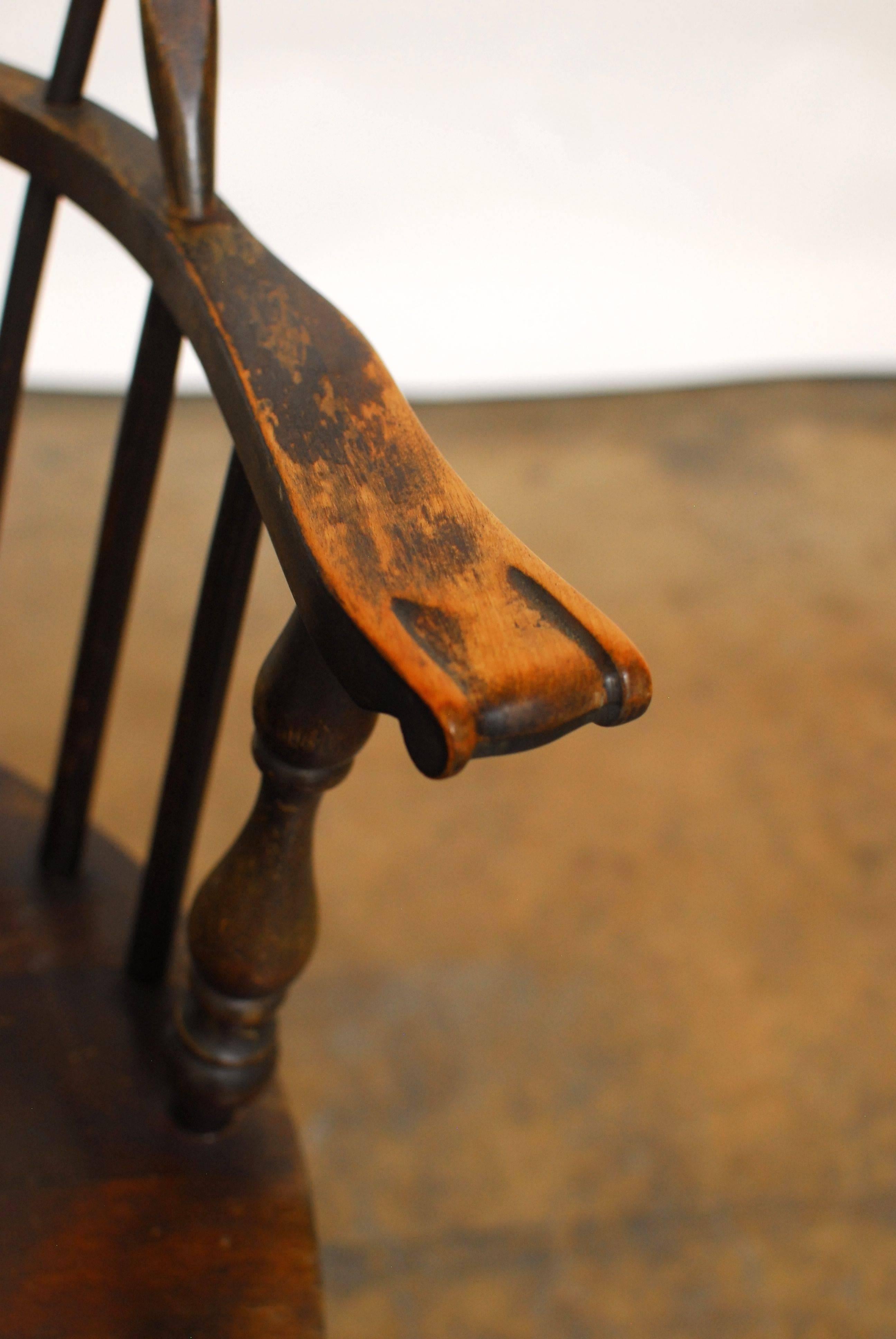 Pair of 19th Century sack back windsor chairs with an arched round crest. Seven spindles are joined to the arm rail and end with carved knuckle hand holds. The base has well splayed turned legs and are joined by a double H form stretcher. The style