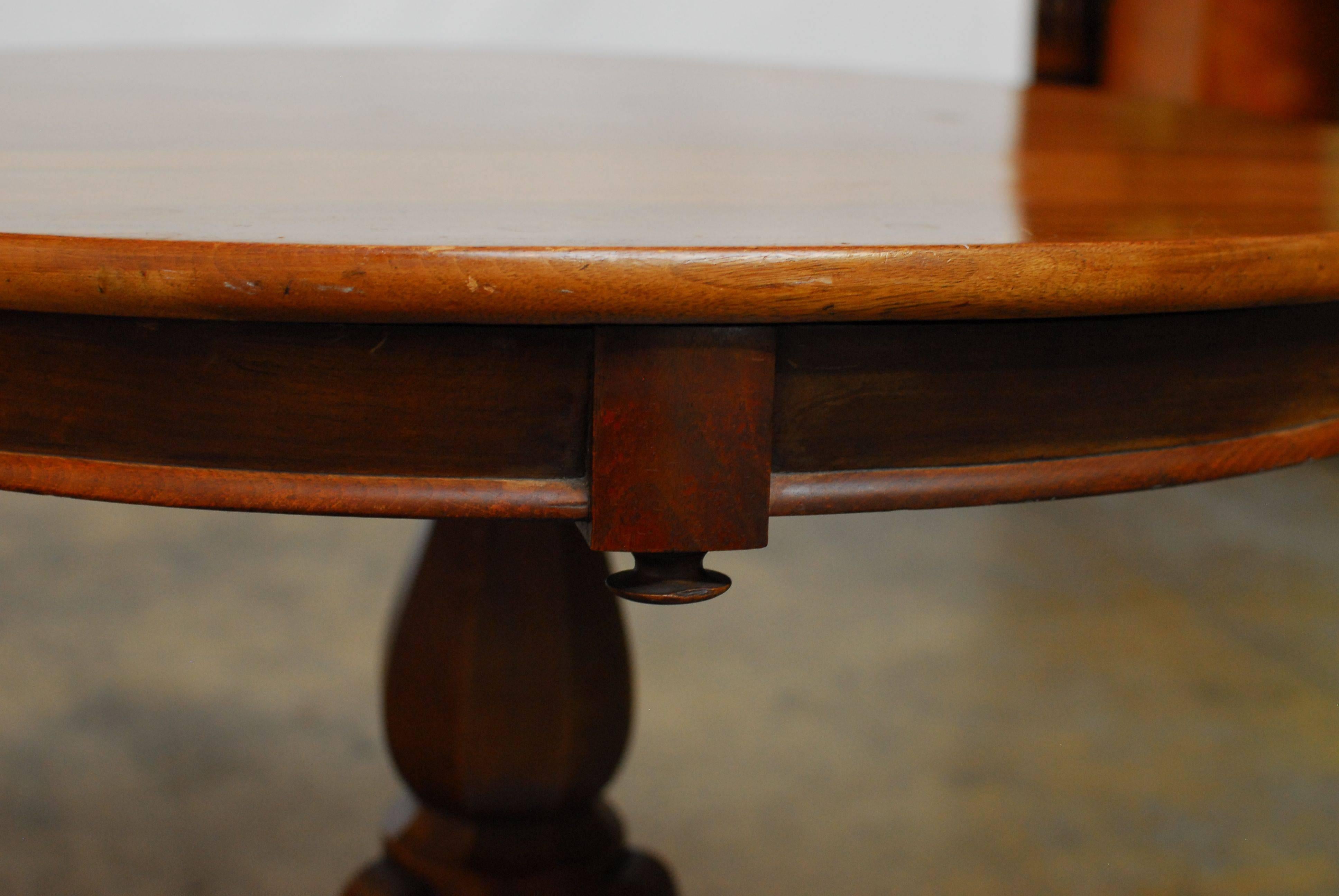 Round 19th century pedestal style breakfast table carved from walnut and sitting on a tripod base. Unique table with an octagonal pedestal base and carved apron with decorative round knobs.