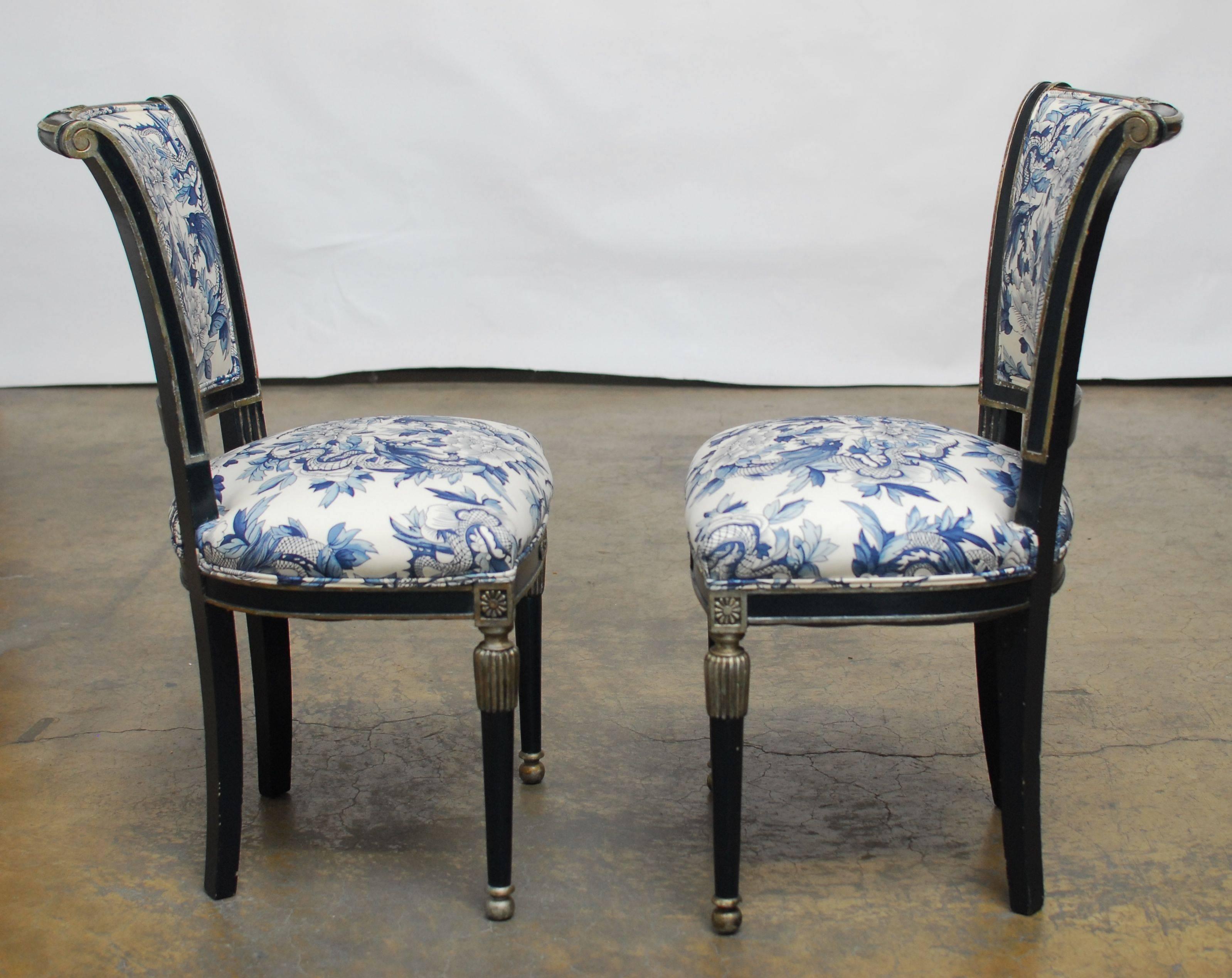 Striking French Directoire style side chairs with a dark royal blue frame and silver banding. Featuring a Ralph Lauren toile chinoiserie blue and white upholstery with dragon and foliate decorations and a double welt border. These beautiful carved