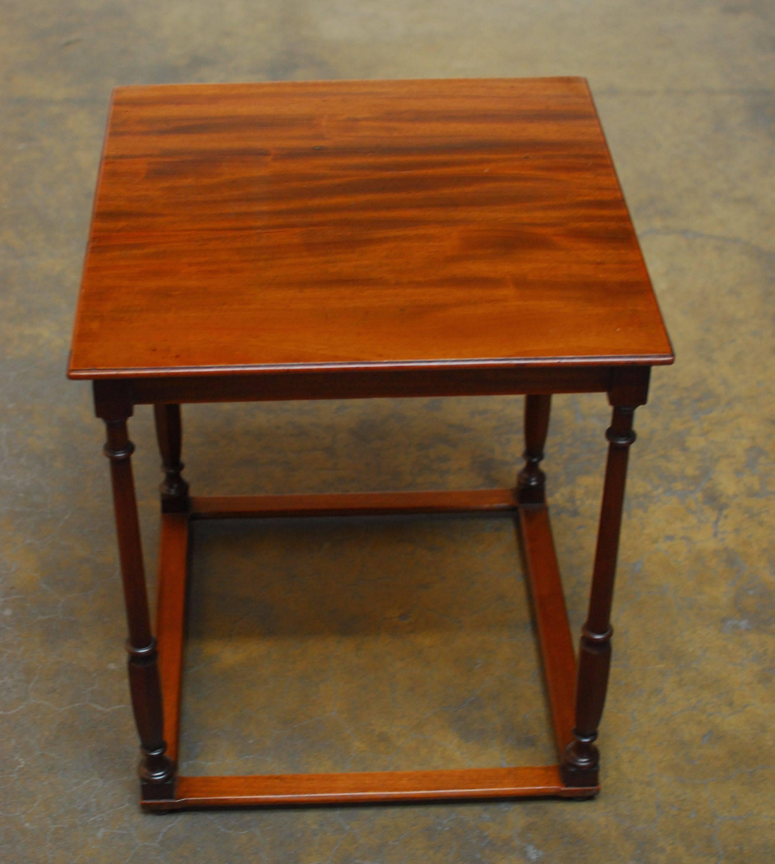 Rare English mahogany pub table or side table sitting on delicate turned legs with a flat box stretcher base. Finished with deep mahogany legs and a contrasting lighter top and bottom.
  