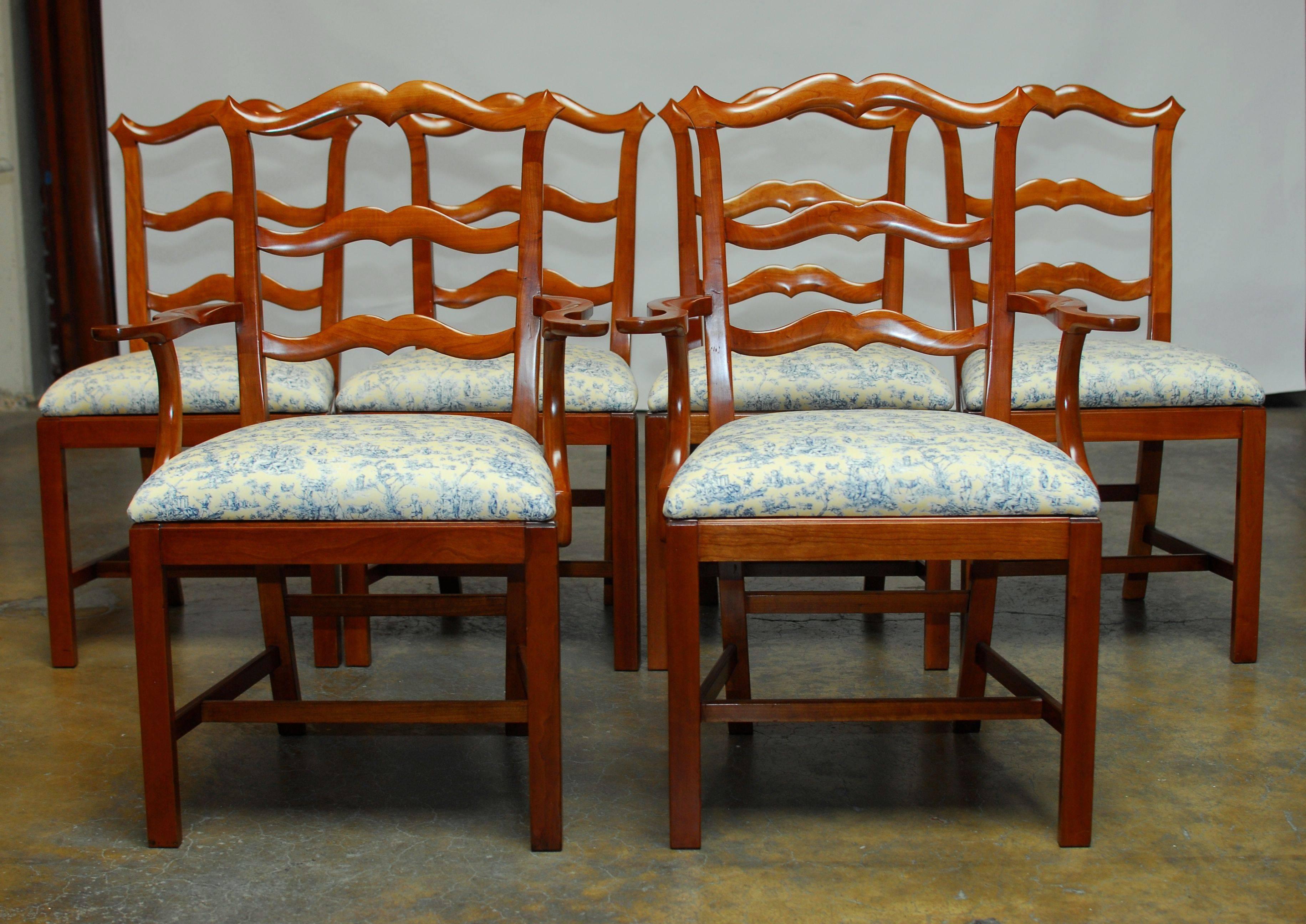Set of six stately Chippendale style dining chairs featuring a ladder back or ribbon back design. The top crest has peaked corners and resembles a French mustache and is complimented by a delicate yellow and blue French toile upholstery. This