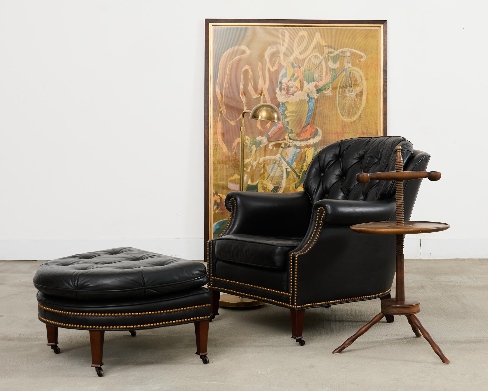 Unverwechselbarer Lounge- oder Clubsessel aus schwarzem Leder mit passender Ottomane, hergestellt im englischen Regency-Stil von Schafer Bros. Der Stuhl hat einen Mahagoni-Rahmen mit runder Rückenlehne und getufteten Rückenkissen im
