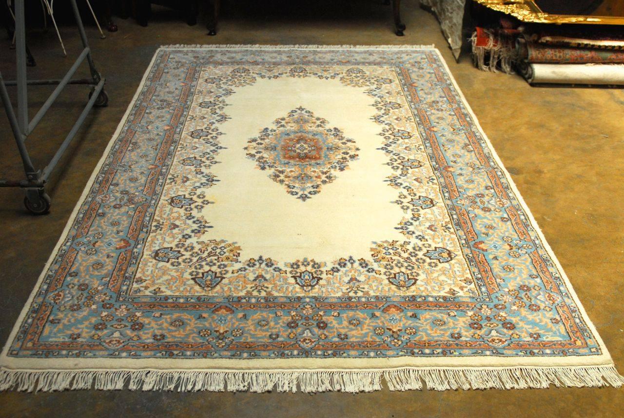 Stunning Kirman carpet made entirely with finely hand-knotted wool. Featuring vivid turquoise, persian blue, khaki, mauve, and brown colors with a central medallion on a cream ground. Floral borders with intricate vine patterns. Gorgeous persian