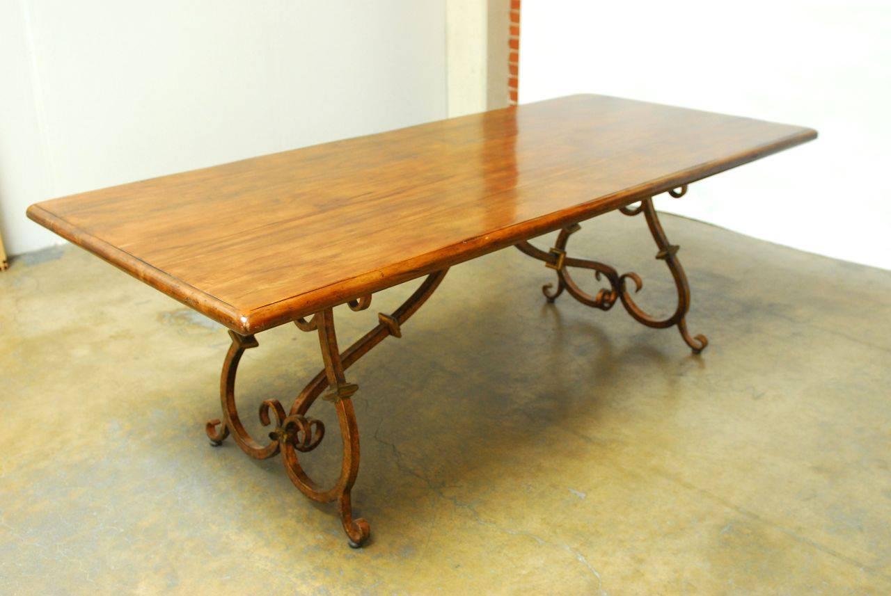 Fantastic Spanish Colonial style trestle dining table made in Italy and featuring a handcrafted wrought iron base with beautiful scrolled legs and spreaders. Constructed from planks of old mahogany and joined together with butterfly joinery. Very
