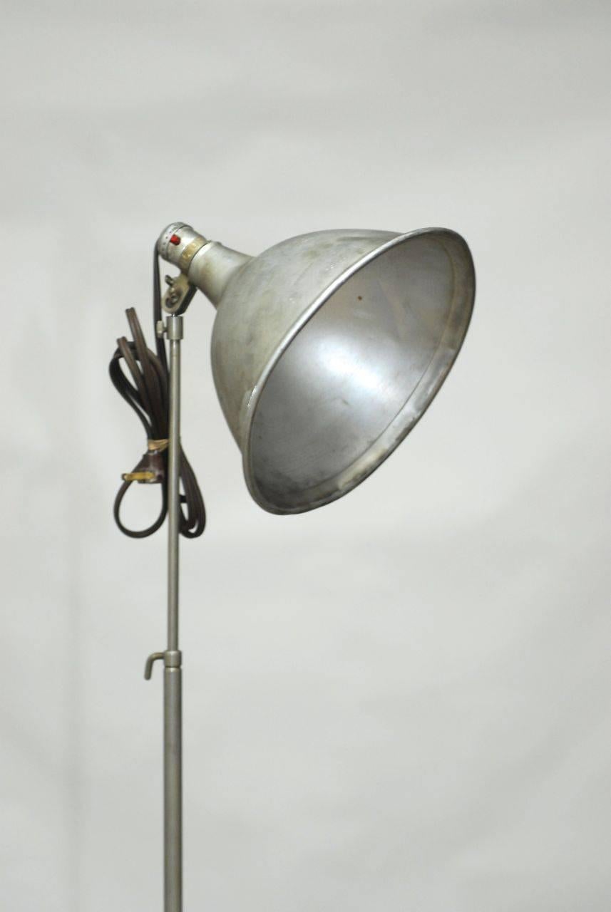 Vintage Industrial tripod lamp made by Smith Victor featuring an adjustable height pole and supported by a tripod base. Stamped Austin Fox-Tiffany Studio Los Angeles, CA. Rises to over 90