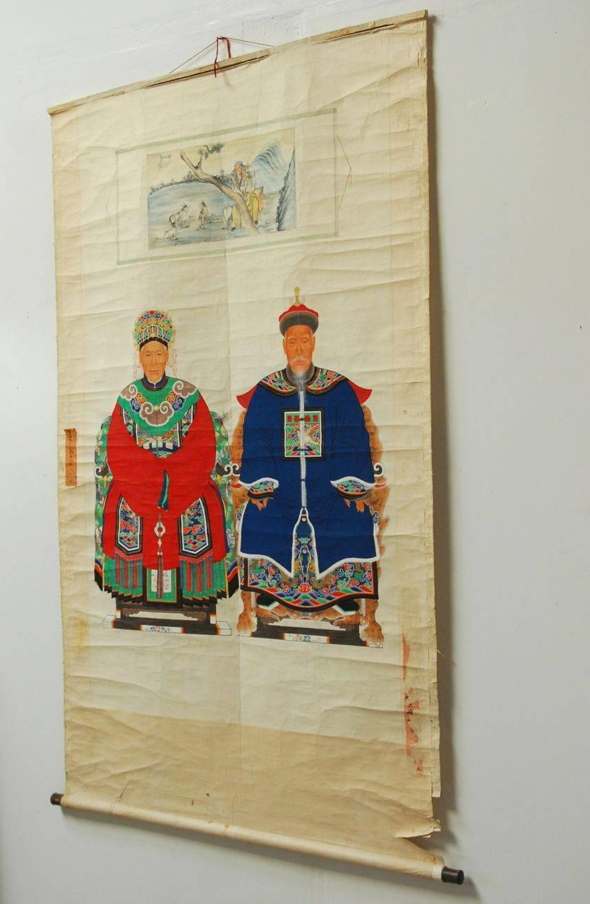 Magnificent Chinese scroll ancestor painting showing patriarch and matriarch of a high ranking status civil official. This unusual scroll depicts the dignitary couple seated below a painting of a scroll with a goat herder in a pastoral setting. The