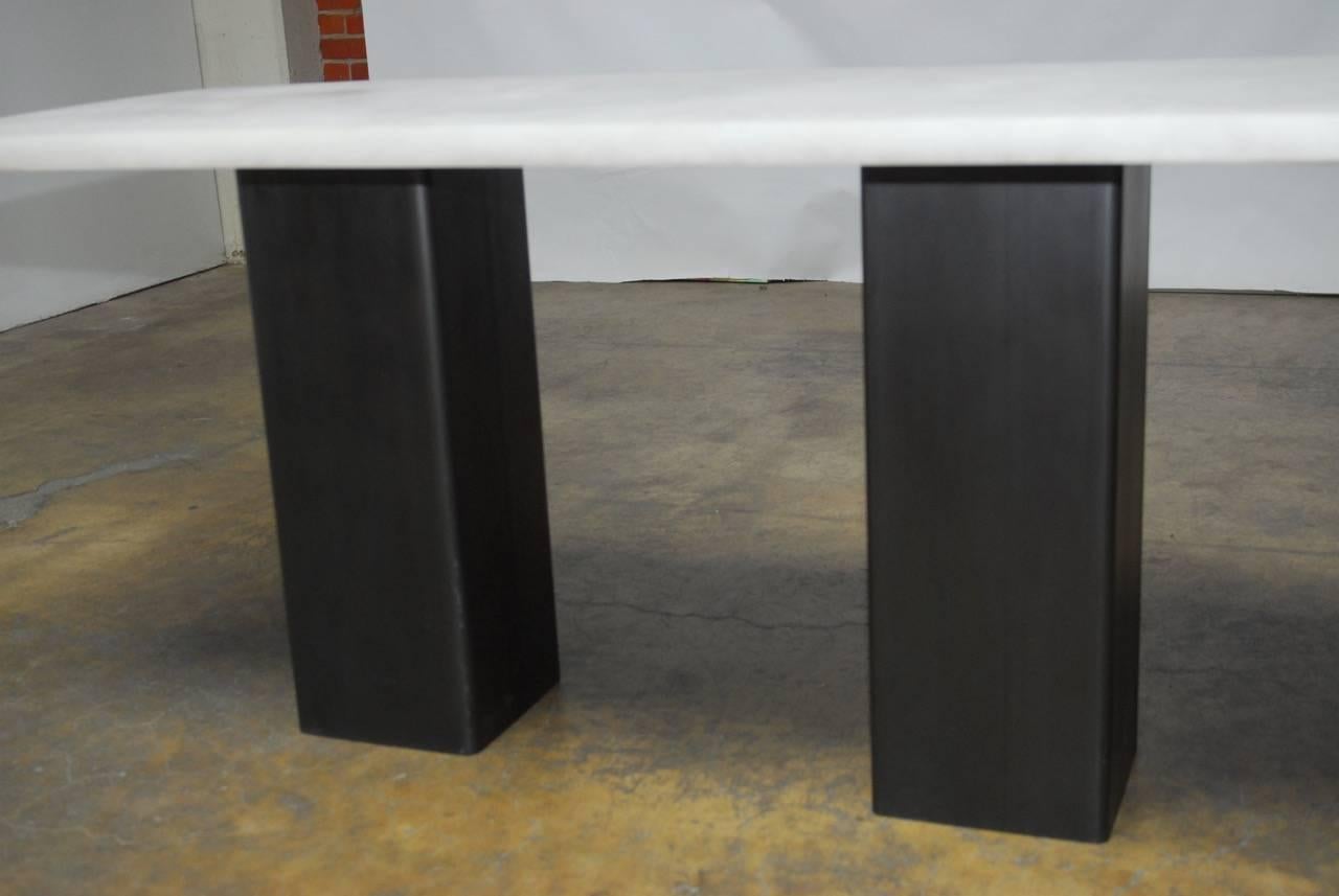 Unique modern design console table featuring a semi translucent faux marble top. Supported by a double pedestal constructed of steel with an anodized gun metal grey finish and round corners. The Industrial steel modern style of the base is highly