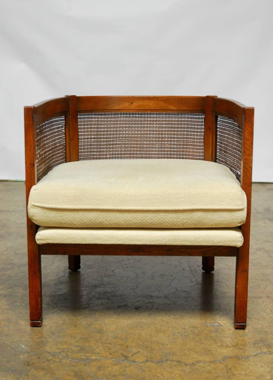 Unique pair of barrel back tub chairs featuring a caned back and sides. Produced by Barker Brothers in Los Angeles, CA circa 1960. Low slung club chairs with original thick upholstered pads and cushions. Upholstery is in excellent vintage condition