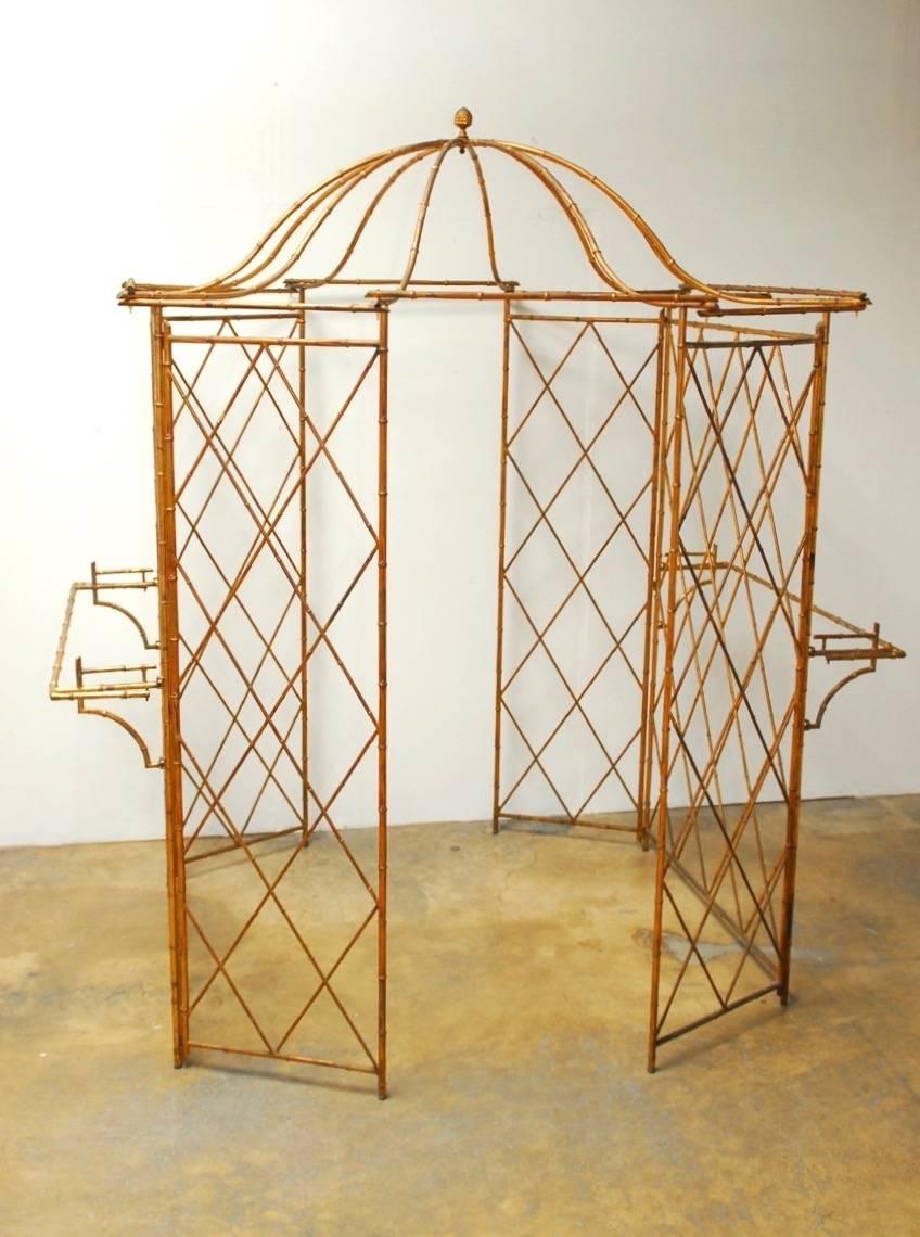 Fantastic Hollywood Regency gilt metal faux-bamboo garden gazebo featuring a pagoda roof with ten arm supports and topped with an acorn finial. Beautiful architectural element made of six panels with a cross hatch design and a 29