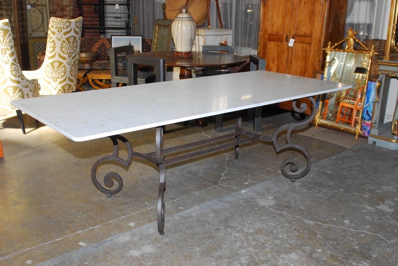 Dramatic Italian marble-top dining table with a hand-forged solid iron base featuring a 1" inch thick slab of white Carrara marble. Custom-made in Italy with large scrolled legs and ball feet conjoined with stretchers. The marble slab has a