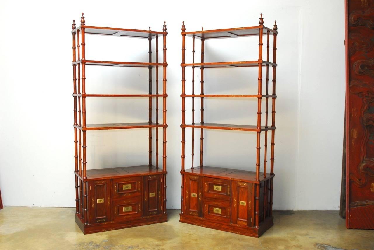 Magnificent pair of Anglo Indian five shelf étagère display cabinets constructed from rosewood. Made in the Campaign style these bookcases have faux bamboo supports and shelves that disassemble. Each shelf and cabinet feature a delicate brass metal