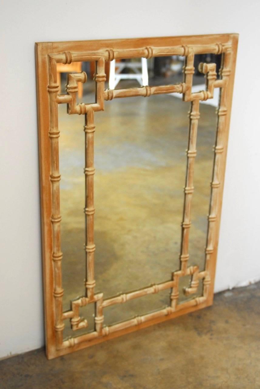 Stylish Hollywood Regency carved faux-bamboo mirror made in the manner of La Barge. Features a symmetrical Greek key motif with a light white washed wood finish. Could be hung horizontal as well since the Greek key pattern is on all four corners.