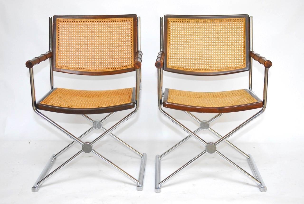 Stylish pair of Mid-Century chrome and caned directors chairs with faux bamboo arms and walnut seat and back. Featuring a chrome-plated metal 