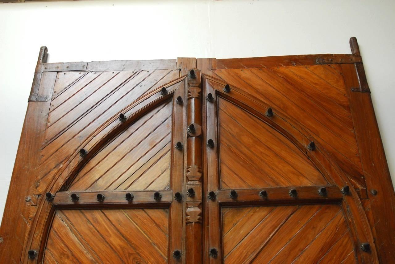 Massive 19th century wooden Moorish style gatehouse doors or castle doors from Spain. Constructed from 19th century large timber frames featuring a smaller opening door on the left side with chain pull and lock. Remodeled and rebuilt in the 20th