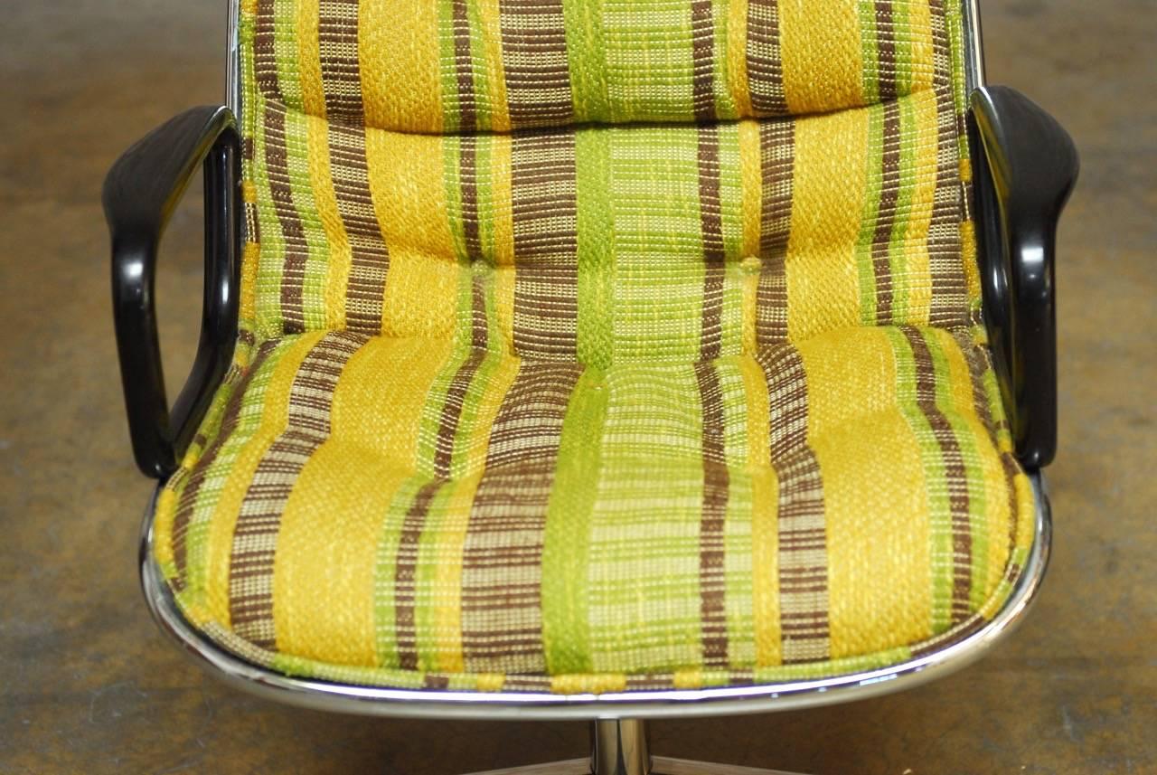 Fabulous Mid-Century executive chair by Charles Pollock for Knoll featuring a stylish striped upholstery in a tufted yellow, brown and green color. The fabric is bordered by a welt that contours the thick chrome frame. Iconic armchair with a funky