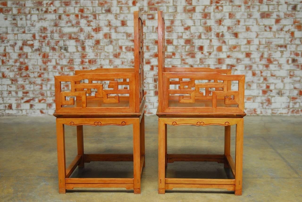 Stunning pair of Chinese carved hardwood armchairs made in the Ming style featuring an open fretwork Greek Key design, frame and an inset back splat with Dali marble and rich Huali rosewood inlay. These armchairs were made with generous proportions