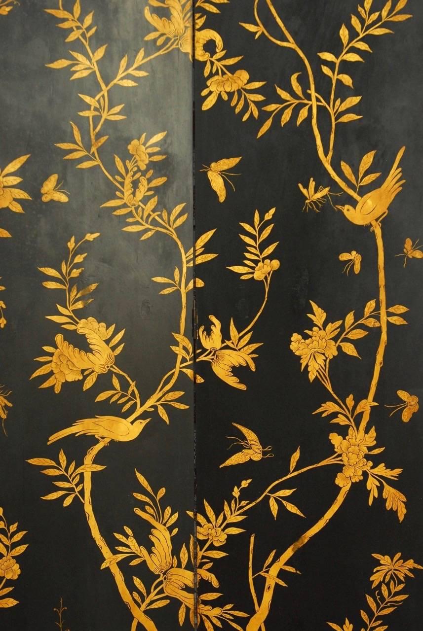Fantastic Chinese black lacquer four-panel screen decorated with climbing vines of flora and fauna. Intricate hand-painted details stand out on a black lacquer ground screen supported by shaped feet. The screen has a beautifully distressed finish